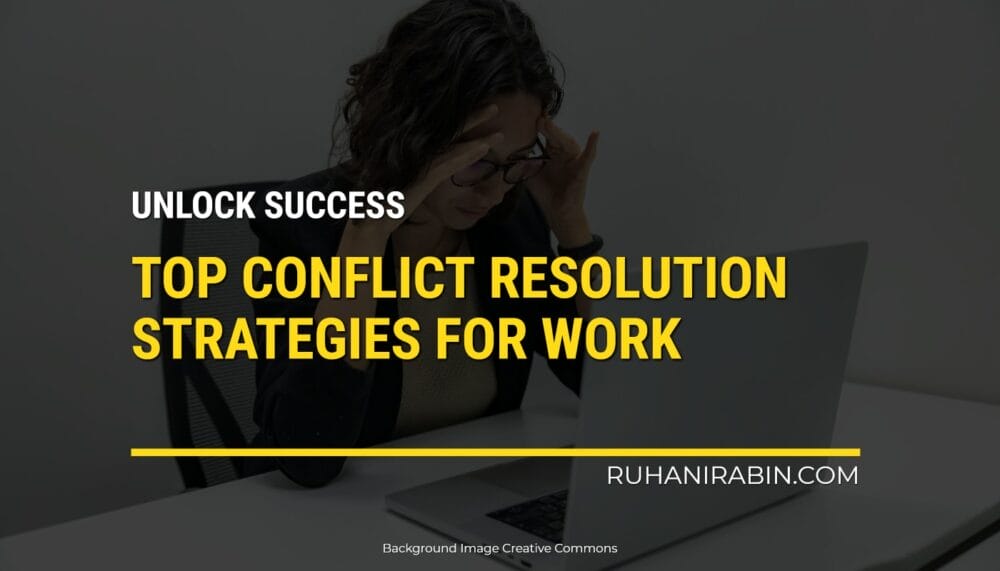 A person sitting at a desk with a laptop looks stressed, holding their head. The text on the image says: Unlock Success. Best Ways to Solve Conflicts at Work. Website: ruhanirabin.com. The background image is under Creative Commons license.