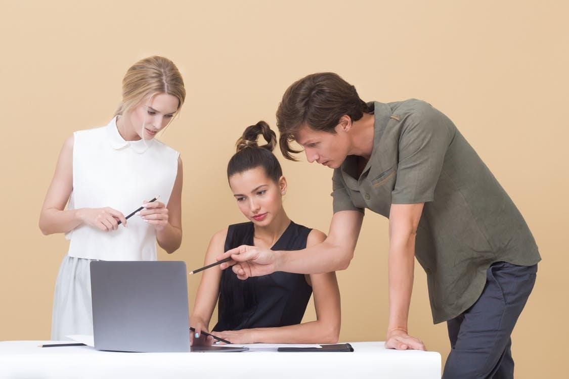 Two Woman and One Man Looking at the Laptop - logo