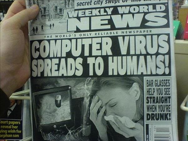 A person is holding a tabloid newspaper that has the headline "Computer Virus Spreads to Humans!" Below this, there's a picture of a worried woman wiping her nose. Another smaller headline says, "Bar Glasses Help You See Straight When You're Drunk!