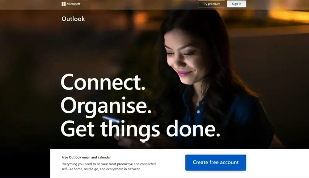 A woman looks at her phone. The words on the screen say: Connect. Organize. Get things done. Find the best Gmail alternative and sign in or create a free Outlook account.