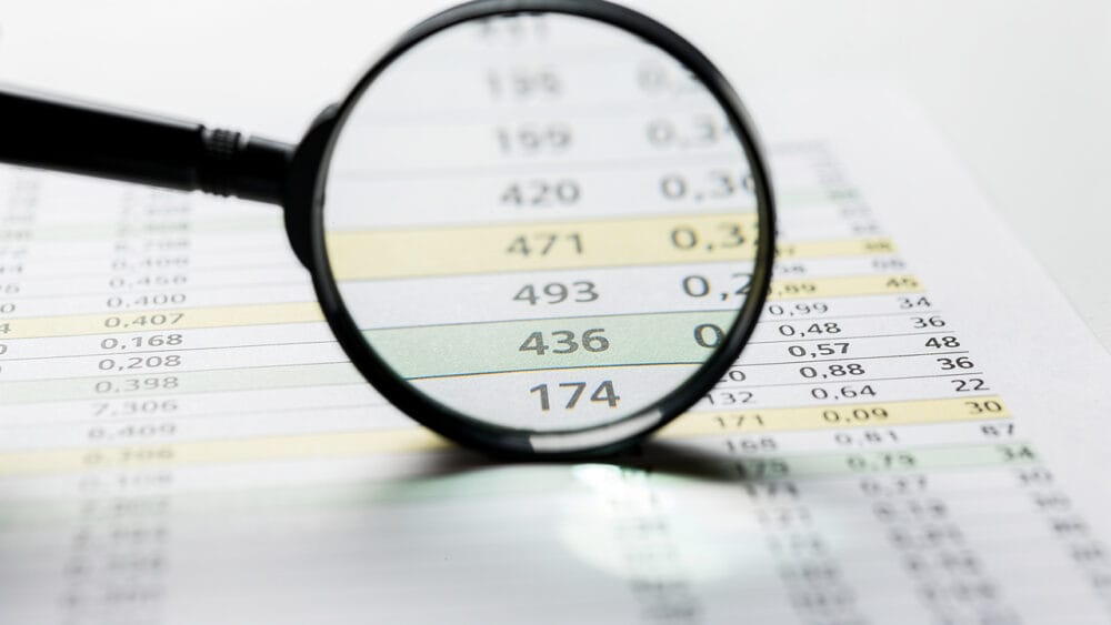 Magnifying glass over a spreadsheet with numbers, highlighting "436." Data analysis for SEO audit.